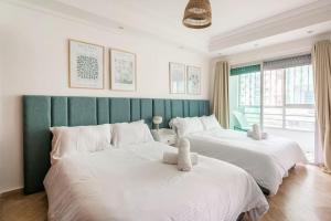 - 2 lits blancs dans une chambre avec un mur vert dans l'établissement TT Holidays 2Bedrooms /Casa city center, à Casablanca