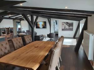 a dining room with a wooden table and leather chairs at Gutshofwohnung - Speicher-Loft in Klein Upahl
