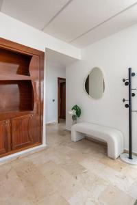 Cette chambre blanche dispose d'une porte en bois et d'un banc. dans l'établissement TT Holidays 2Bedrooms /Casa city center, à Casablanca