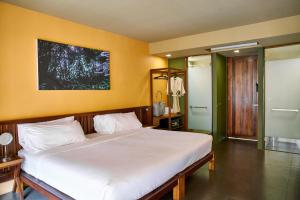 a bedroom with a large white bed with yellow walls at Avatar Railay in Railay Beach
