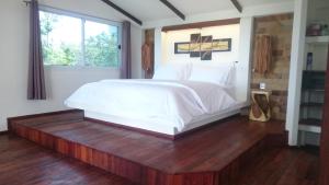 a bedroom with a white bed on a wooden floor at Horizon Luxury Pool Villas Koh Tao in Ko Tao