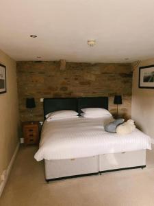 a bedroom with a white bed with a brick wall at The Cheviot Hotel in Bellingham