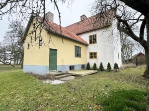 a white house with a green door in a yard at Genuine Gotland house with large garden in Roma in Romakloster