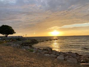 a sunset over the ocean with a rocky beach at Genuine Gotland house with large garden in Roma in Romakloster