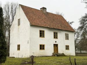 a large white building with a brown roof at Genuine Gotland house with large garden in Roma in Romakloster