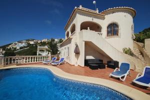 une villa avec une piscine en face d'une maison dans l'établissement Villa Higeron, à Cumbre del Sol