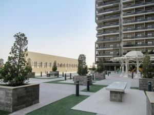 a courtyard with benches and a large building at Frank Porter - Elite Sports Residence in Dubai