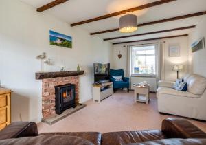 a living room with a fireplace and a couch at Gilfach Ceidio in Morfa Nefyn