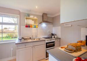 a kitchen with white cabinets and a counter top at Gilfach Ceidio in Morfa Nefyn