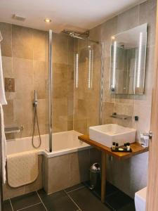 y baño con bañera, lavamanos y ducha. en The Cheviot Hotel, en Bellingham