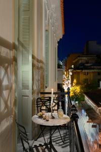 una mesa y sillas en un balcón con una vela en Beautiful Athens Apartment | 1 Bedroom | Apartment Gildarts | Furnished Balcony Overlooking the City | Athinaidos en Athens