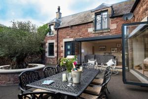 a patio with a table and chairs and a building at Coledale Stables in Kelso