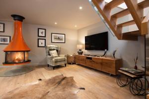 a living room with a tv and a fireplace at Coledale Stables in Kelso