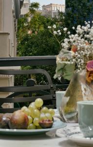 a plate of fruit on a table on a balcony at Luxury Athens Apartment | 2 Bedrooms | Apartment Mavis | Spacious Terrace with Hot Tub and Stunning City Views | Athinaidos in Athens