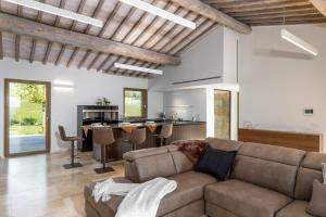 ein Wohnzimmer mit einem Sofa und einer Küche in der Unterkunft Villa Velari In Volterra With Private Pool, AC in Volterra