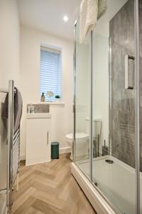 y baño con ducha y aseo. en Modern 5 Bedroom Fully upgraded with Free Parking, en Earlham
