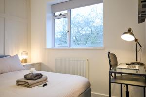 1 dormitorio con cama, escritorio y ventana en Modern 5 Bedroom Fully upgraded with Free Parking en Earlham
