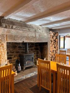 a dining room with a wooden table and a fireplace at The Cheviot Hotel in Bellingham +1 photo