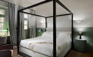 een slaapkamer met een zwart hemelbed met witte kussens bij Stunning Athens Apartment | 1 Bedroom | Apartment Juvia | Athinaidos in Athene