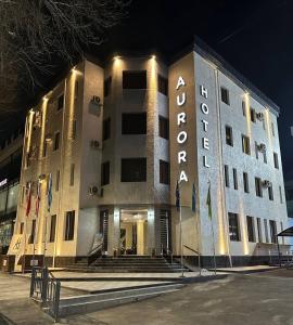 duży budynek z znakiem na nim w nocy w obiekcie Aurora Hotel w Taszkiencie