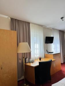 a hotel room with a desk and a television at Hotel Bonverde (Wannsee-Hof) in Berlin