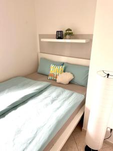 a bed with two pillows on it in a bedroom at Apartment Cuore del Lido in Lignano Sabbiadoro