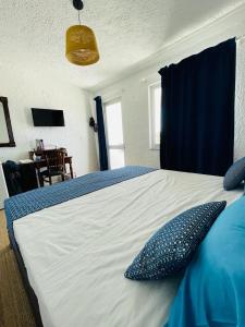 a bedroom with a bed with blue pillows on it at LASSION GOLDEN BAY Sea view in Sitia