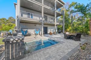 a house with a swimming pool and a patio at North Myrtle Beach Home - Walk to the Ocean! in Myrtle Beach