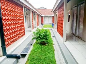 un pasillo vacío de un edificio escolar con una planta en Saijaan Yogyakarta Mitra RedDoorz, en Kejayan