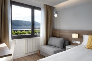 a bedroom with a bed and a chair and a window at Hotel Parma in San Sebastián +37 photos