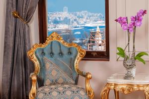 una sedia e un tavolo con un vaso con fiori viola di Ring Stone Hotels Old City a Istanbul