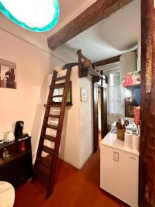 uma cozinha com uma escada ao lado de um frigorífico branco em Abbaye - Appartement spacieux au coeur du Vieux-Nice em Nice