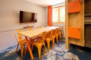 a dining room with a wooden table and chairs at Hotel Base Camp Lodge - Albertville in Albertville