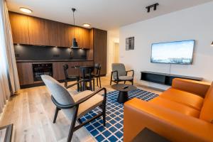 sala de estar con muebles de color naranja y TV de pantalla plana. en Hlemmur Suites, en Reikiavik