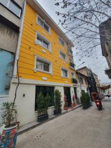 a yellow building with potted plants on a street at st945 Palas Otel in İzmir