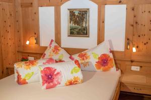Duas almofadas numa cama num quarto de madeira em Obstbauernhof Fohlenhof em Lasa