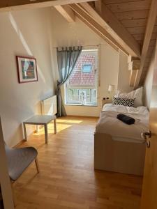 Schlafzimmer mit einem Bett, einem Tisch und einem Fenster in der Unterkunft Landhaus Lindenberg in Buchloe