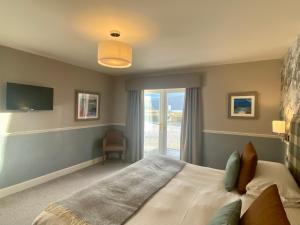 a bedroom with a large bed and a window at Balmacara Hotel in Kyle of Lochalsh