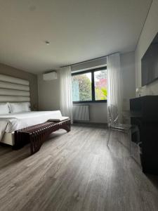 a bedroom with a bed and a window and a desk at Parco Hotel Sassi in Turin