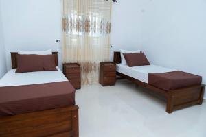 a bedroom with two beds and a window at The Islands Breeze Villa in Dehiwala