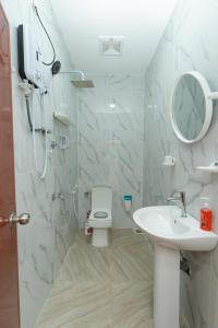 a bathroom with a sink and a toilet and a shower at The Islands Breeze Villa in Dehiwala