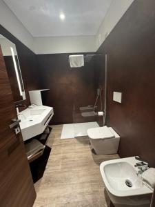 a bathroom with two sinks and a toilet and a shower at Parco Hotel Sassi in Turin