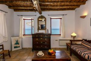 a living room with a couch and a table at Waveside Sanctuary - Luxurious Seastone Villa in Avía
