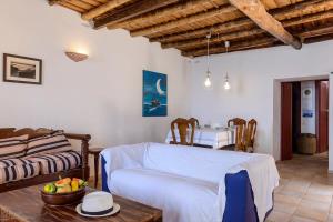 a living room with a couch and a table at Waveside Sanctuary - Luxurious Seastone Villa in Avía