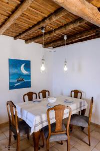 uma sala de jantar com uma mesa branca e cadeiras em Waveside Sanctuary - Luxurious Seastone Villa em Avía