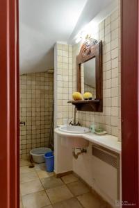 uma casa de banho com um lavatório, um espelho e um WC. em Waveside Sanctuary - Luxurious Seastone Villa em Avía