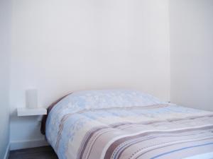 トロワにあるBel Appartement Coeur de Villeの白い壁のドミトリールームのベッド1台分です。