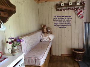 um urso de peluche sentado num banco num quarto em Fernwood em Ringwood