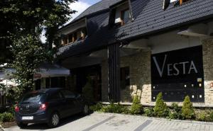 a black car parked in front of a building at Hotel Vesta Centrum Konferencyjno Wypoczynkowe in Jeleśnia