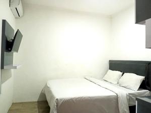 KejayanにあるSaijaan Yogyakarta Mitra RedDoorzの白いシーツ付きのベッドが備わる白い部屋